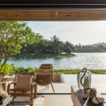 Living room opened fully to the terrace, lake and hills at sunset