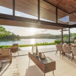 Living and dining room under a lofted timber ceiling with clerestory glazing