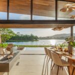 Dining table under the raised roofline with the lake beyond