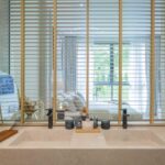 Double-vanity bathroom behind slatted screen
