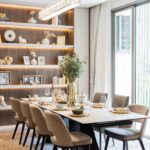 Modern dining room with illuminated shelving, table set for six, and glass doors to terrace